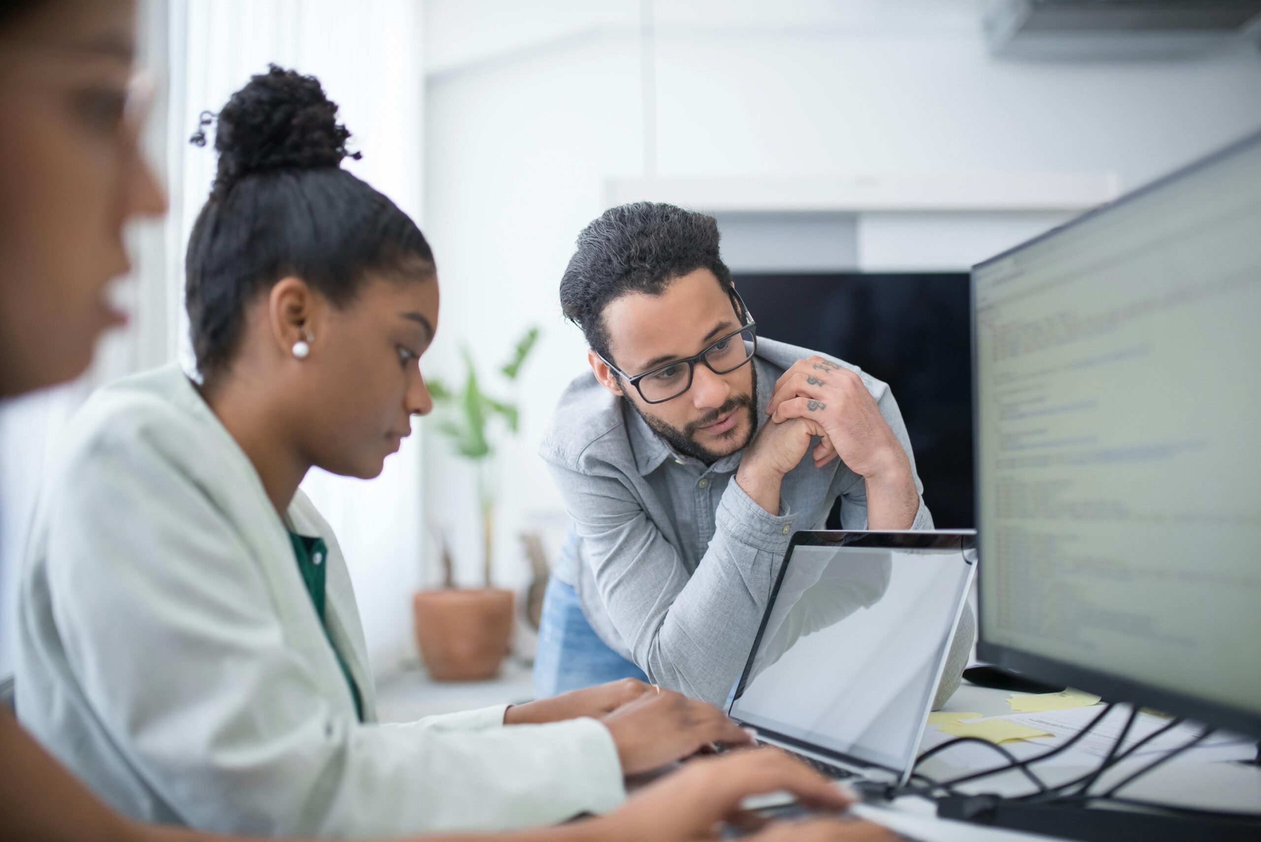 Coworker assisting professional woman in qualifying a prospect.