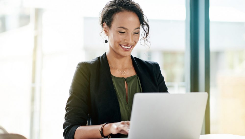 Shot of a young businesswomen using a laptop at her desk in a modern office